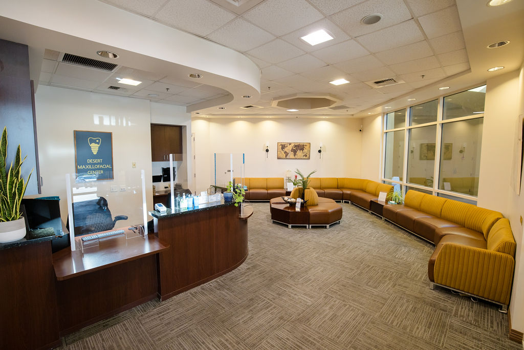 The Desert Maxillofacial Center reception desk and waiting room, with mustard bench seating along the window wall.